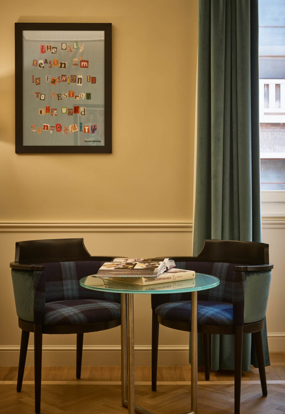 Detail of fashion-themed room at 47 Boutique Hotel with Vivienne Westwood inspirational poster and blue-purple chairs