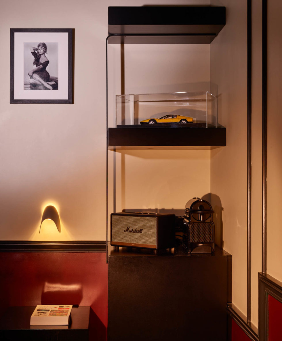 Detail of 1960s-themed room at 47 Boutique Hotel with Brigitte Bardot photo and yellow Ferrari BB model in warm tones